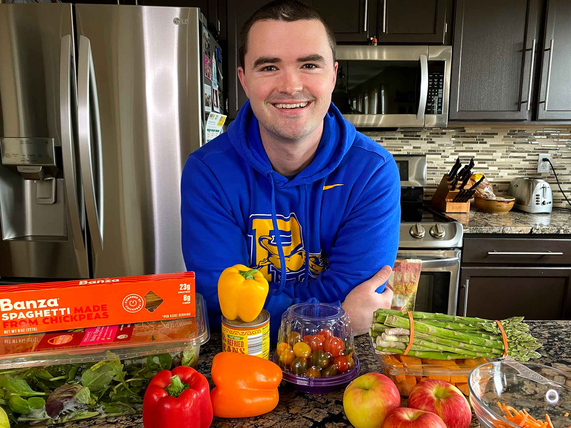 Chris Gates posing with an assortment of plant-based foods