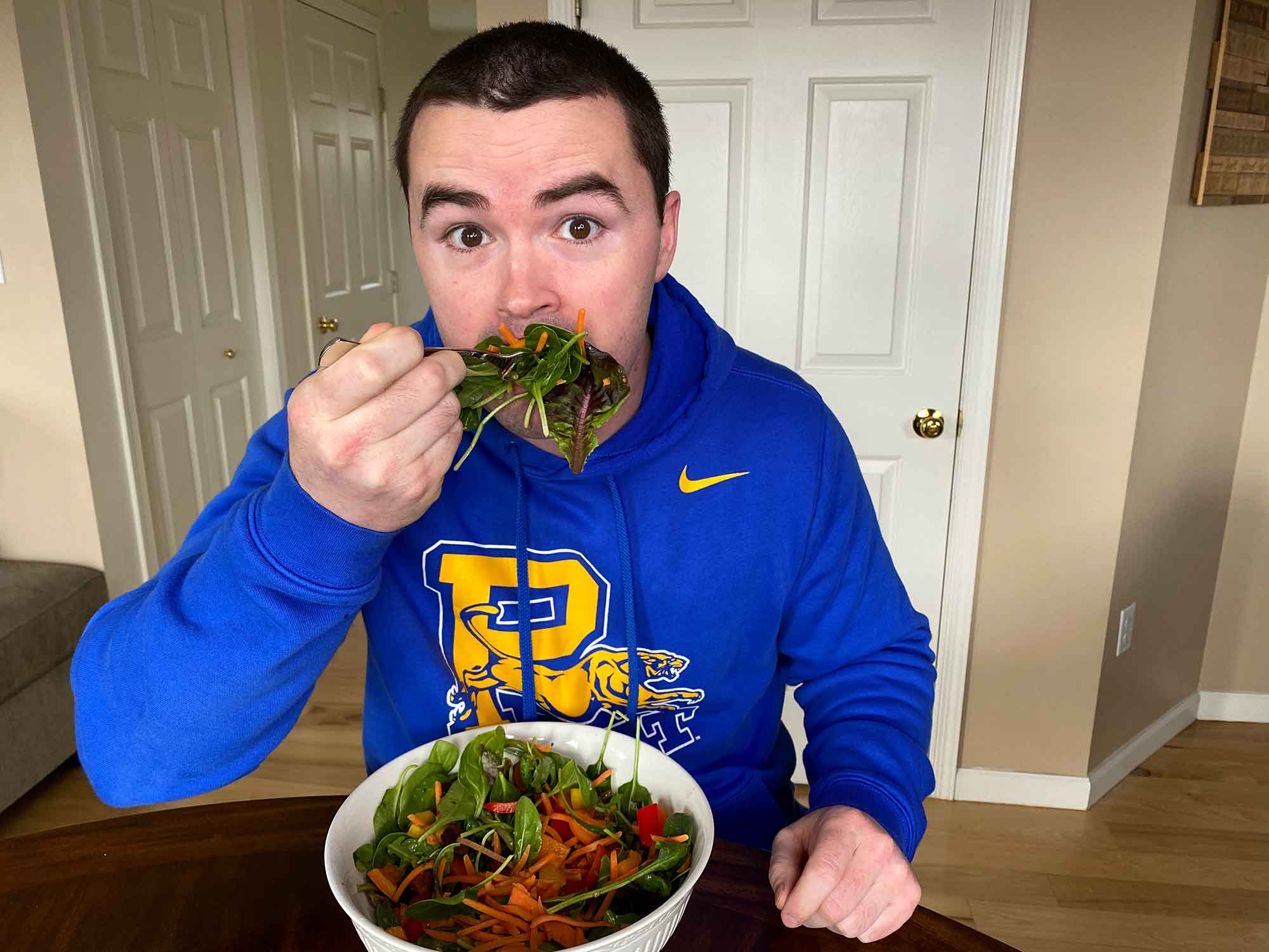 Chris Gates eating a large bit of salad