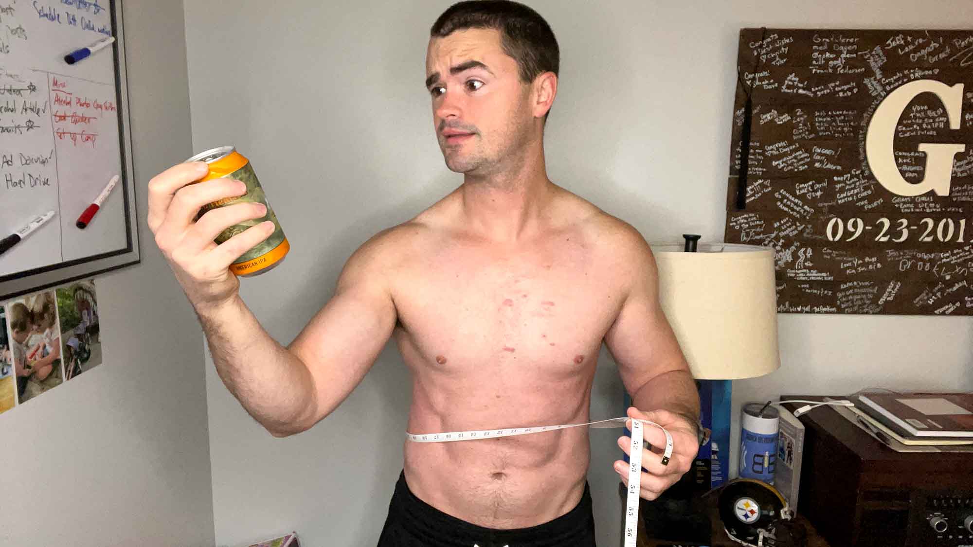 Chris holding a beer and a tape measure with a concerned look on his face