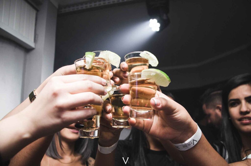 A group of people raising shot glasses for cheers