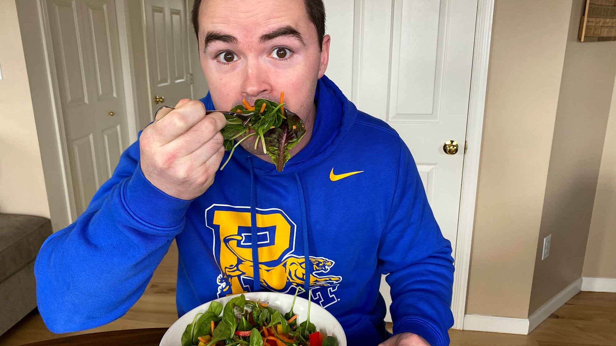 Chris Gates eating a large bit of salad